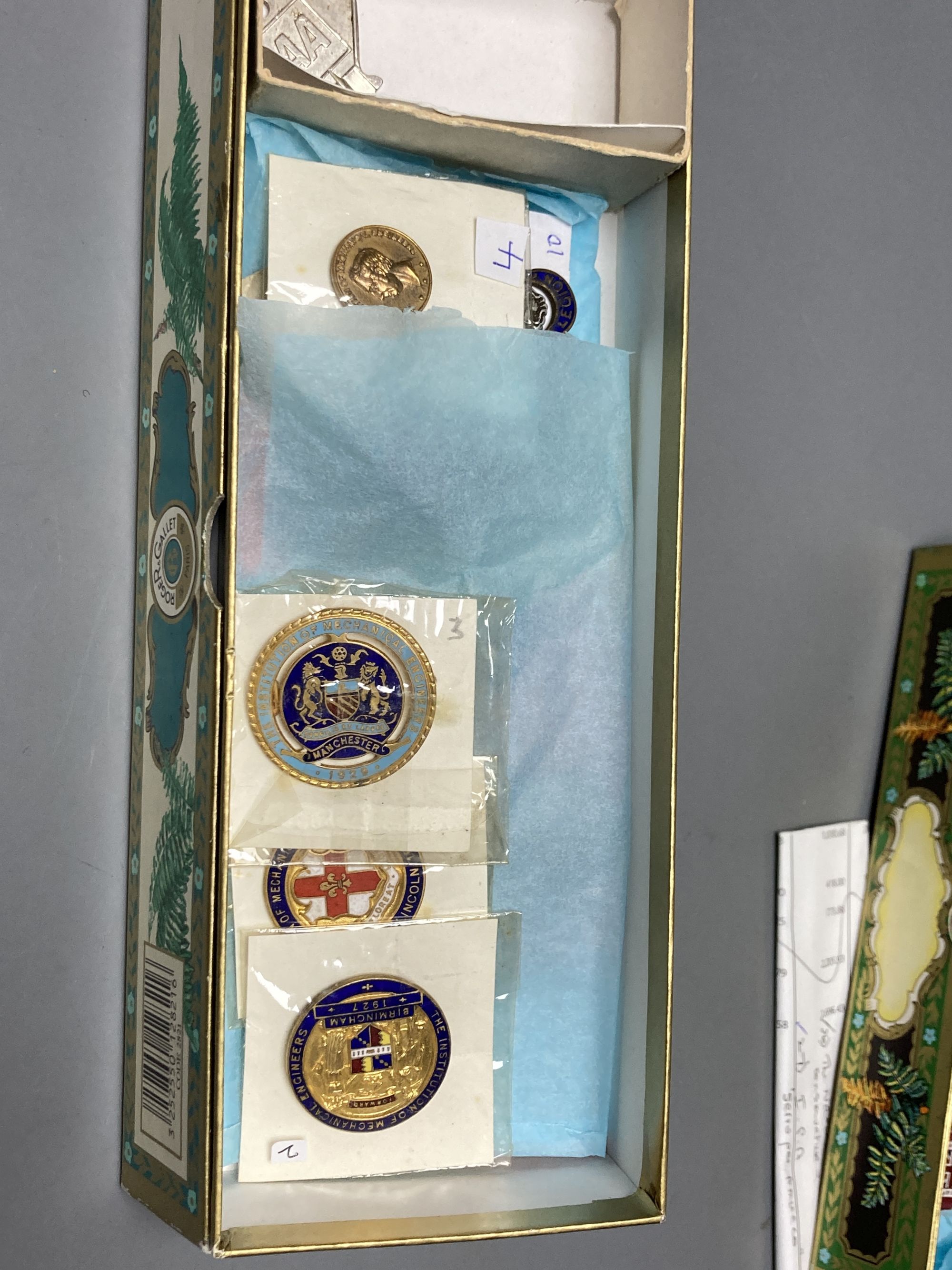 A collection of assorted enamel badges and nursing badges